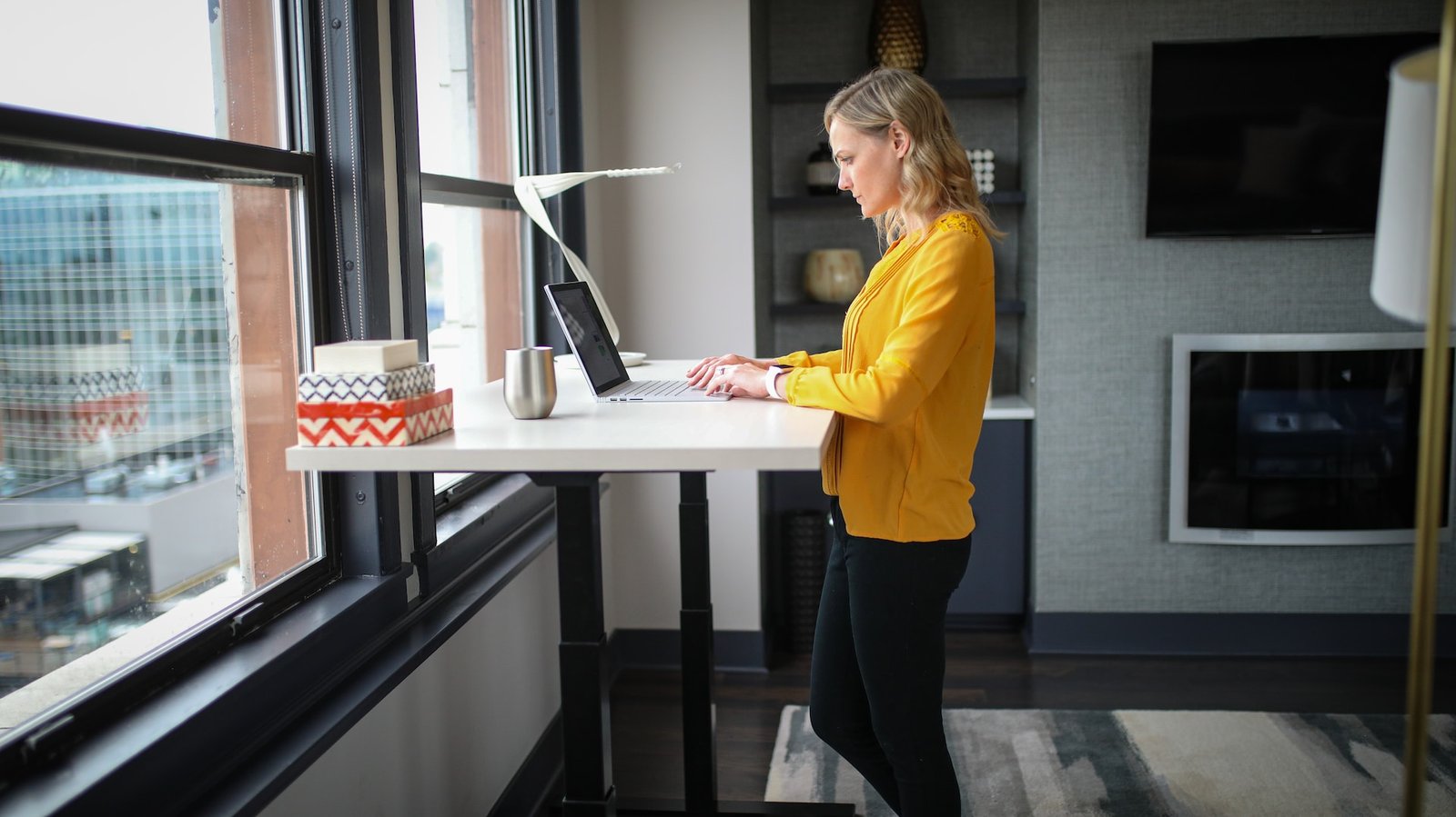 a woman using a standing desk to work